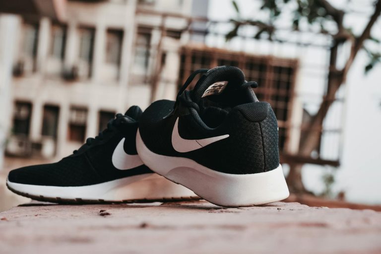macro photography of pair of black and white nike running shoes nike id